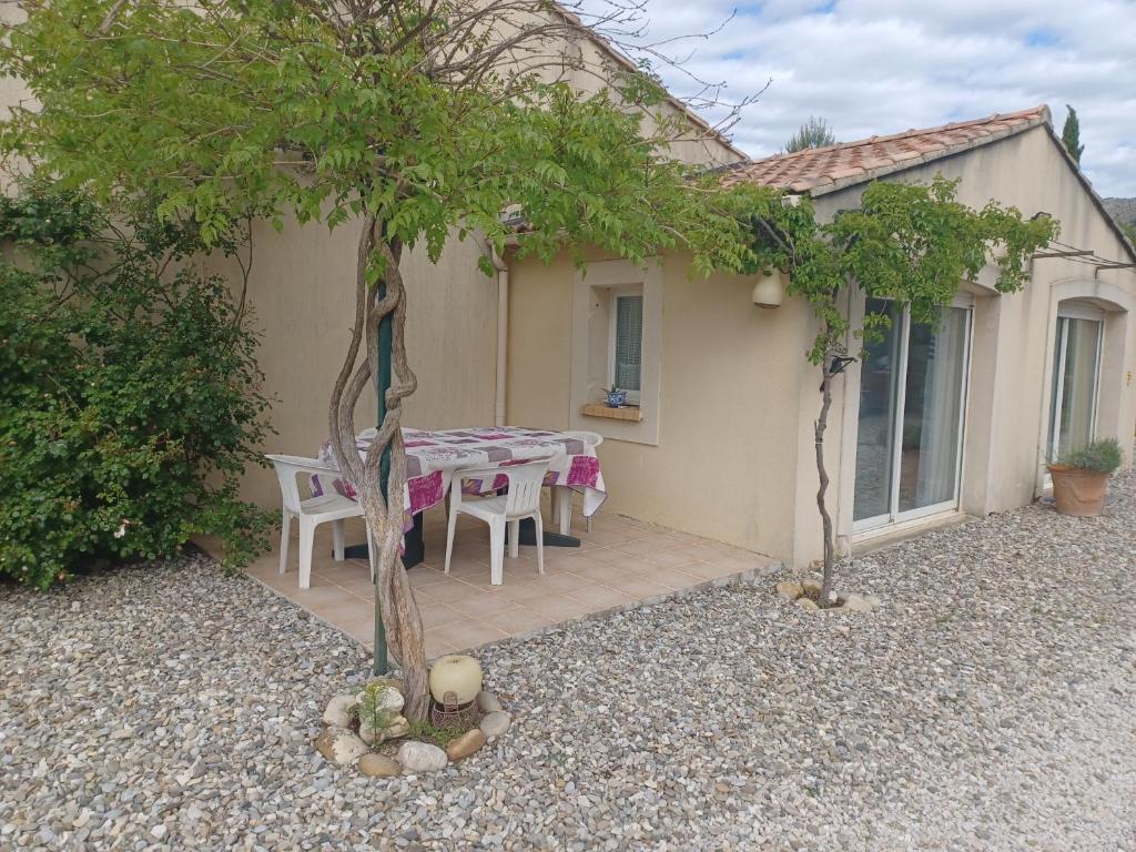 un patio avec une table et des chaises devant une maison dans l'établissement Appartement au pied du Luberon, à Mérindol
