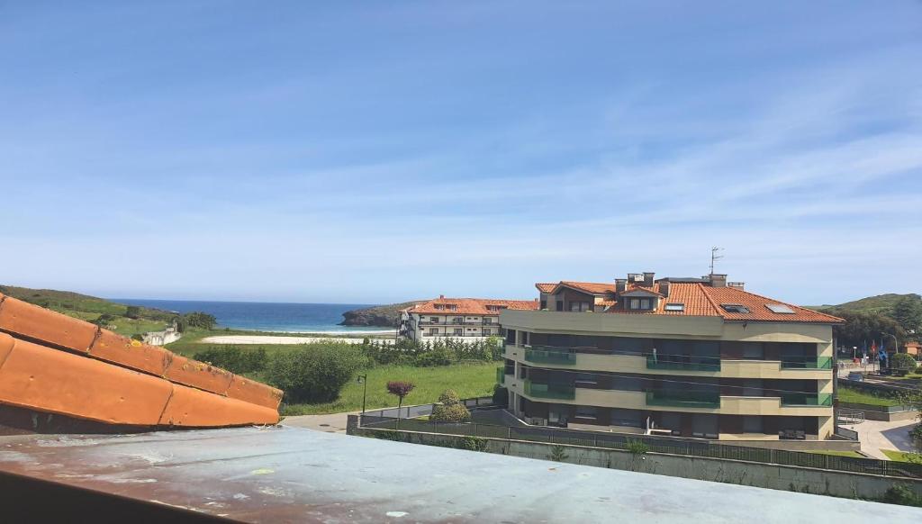 a view of a building with the ocean in the background at "el señor de treville" in Barro de Llanes