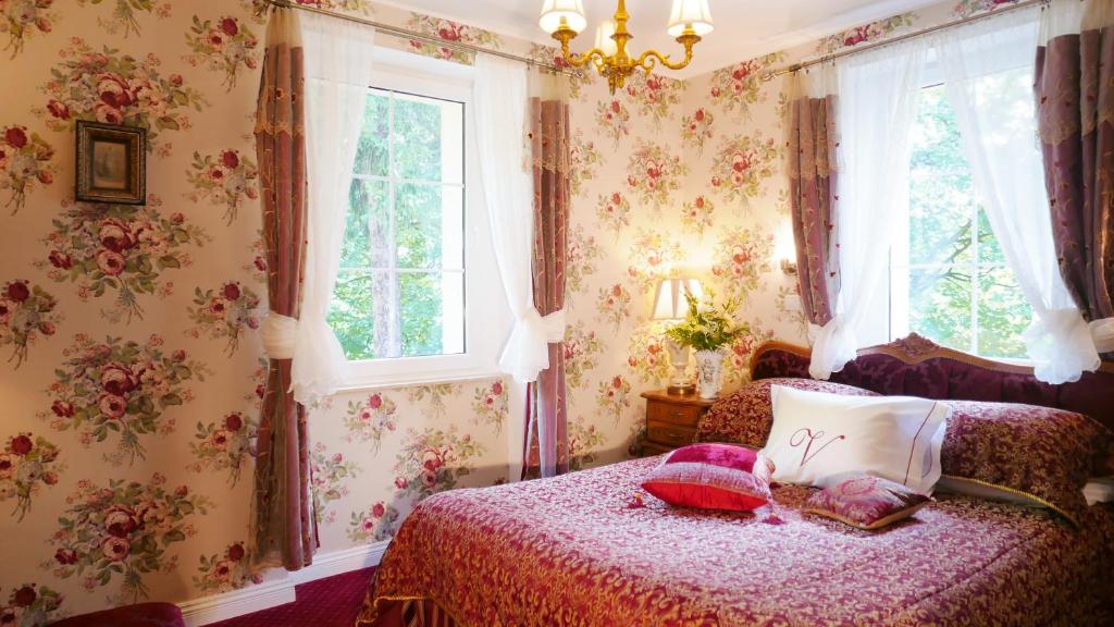 a bedroom with a bed with pillows on it at Rezydencja Grawert Boutique & Spa in Lądek-Zdrój