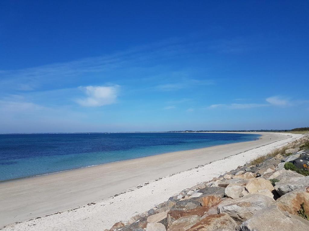 een strand met rotsen en water en een blauwe lucht bij LA POINTE DE SEL in Fouesnant