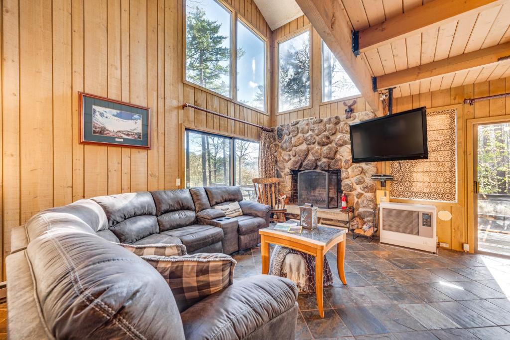 een woonkamer met een bank en een open haard bij All-Season Conway Condo with Private Hot Tub! in North Conway