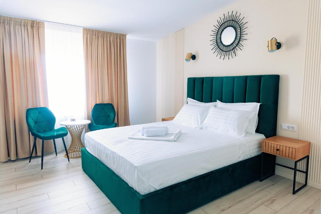 a hotel room with a bed and a table and chairs at Villa Twins Techirghiol in Techirghiol