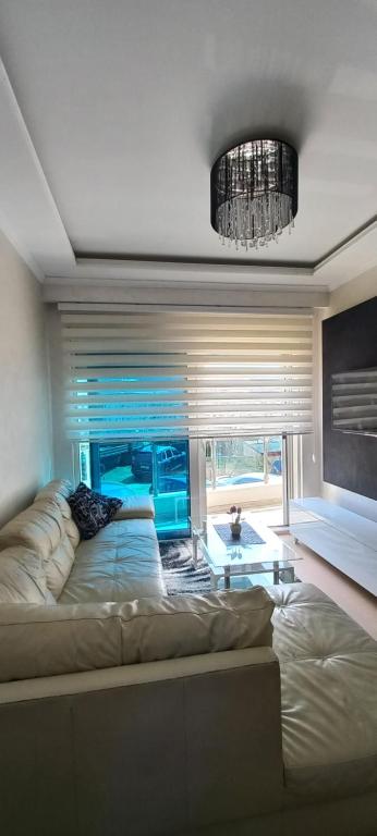 a living room with a large bed and a chandelier at LoreHan apartman 2 in Becici