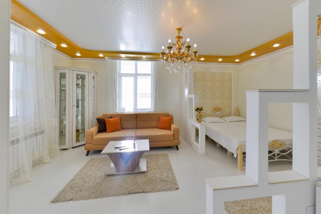 een woonkamer met een bed en een bank bij Однокомнатные апартаменты на Мангилик ел 51 in Astana