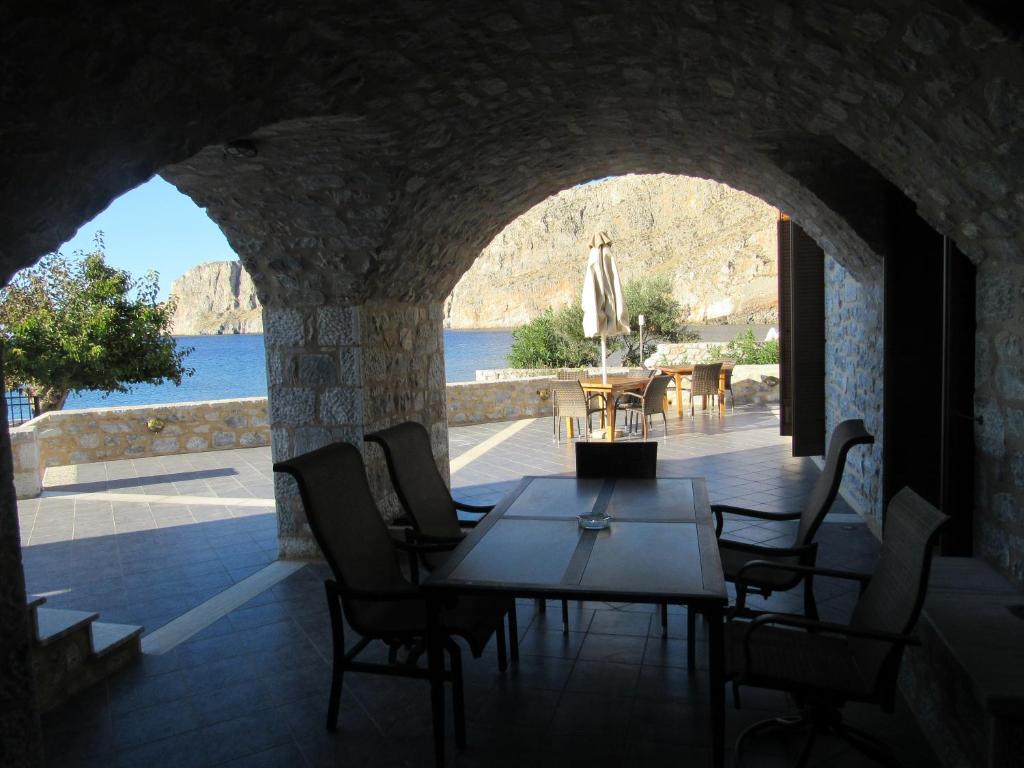 a room with a table and chairs and a view of the water at Kyrimi in Gerolimenas