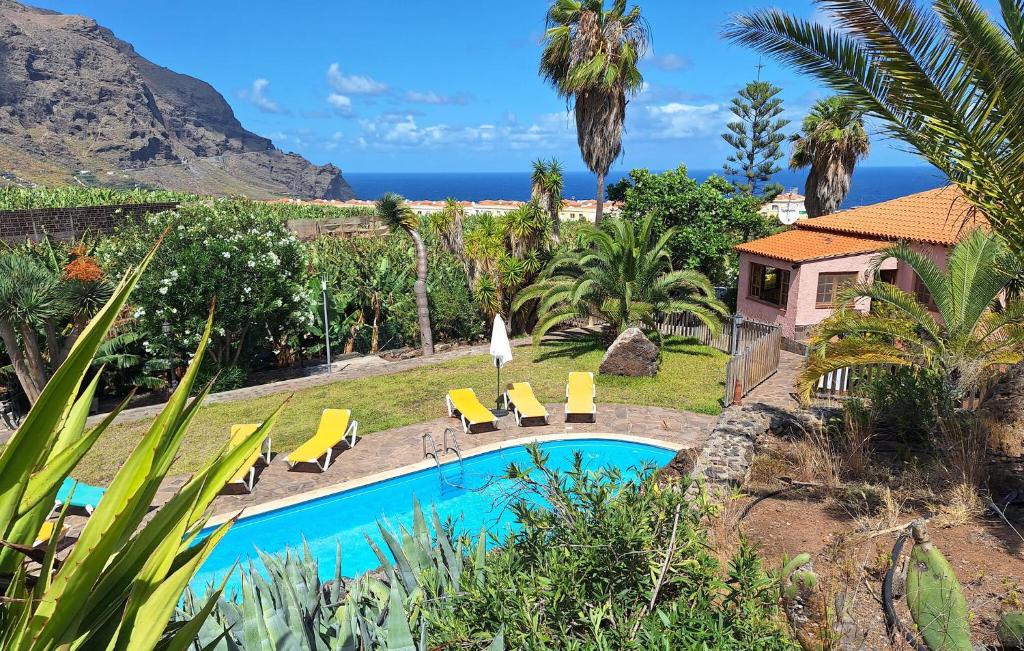 una casa con una piscina con sillas y el océano en Finca La Cancela, en Tanque