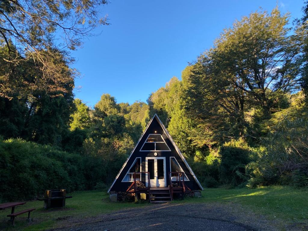 a small cabin in the middle of a forest at Centro Turístico Anticura Parque Nacional Puyehue 