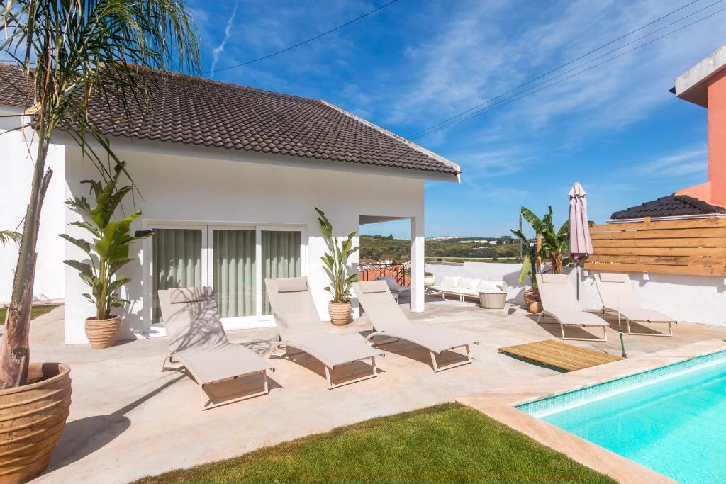 a patio with chairs and a swimming pool at Retreat Villa, Hot tub, BBQ in Lisbon