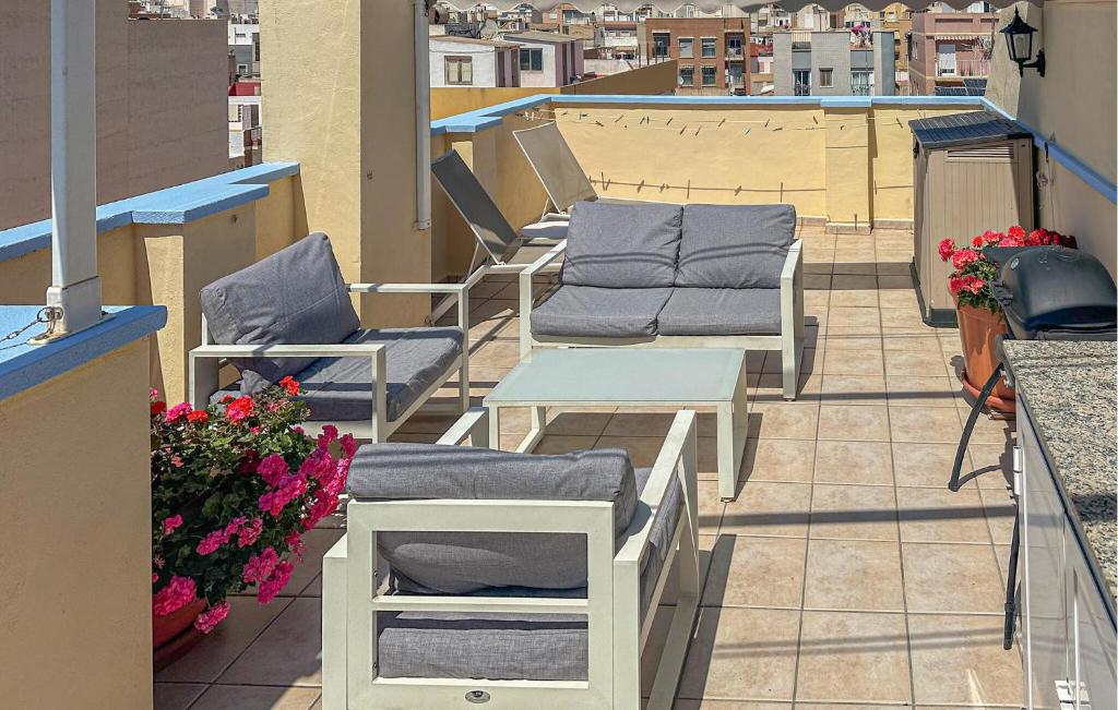 uma fila de cadeiras e mesas numa varanda em Stunning Apartment In Santa Pola With Kitchenette em Santa Pola