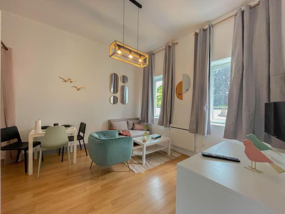 un salon avec un canapé et une table dans l'établissement Le moineau -Poterne -Parking gratuit -Calme-Centre, à Valenciennes