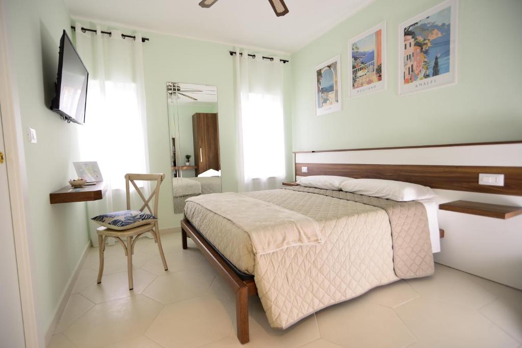 een slaapkamer met een bed en een stoel erin bij MALUSI B&B in Napels
