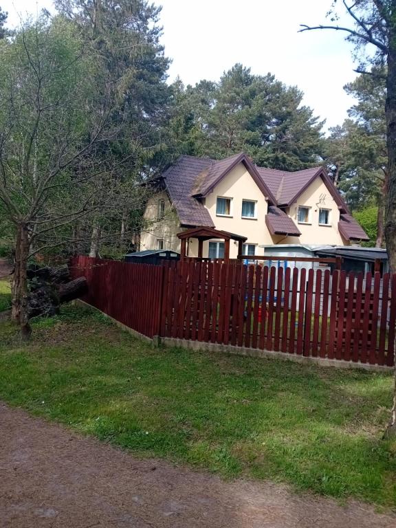 a house behind a red fence at Domimat-Lila in Dębki