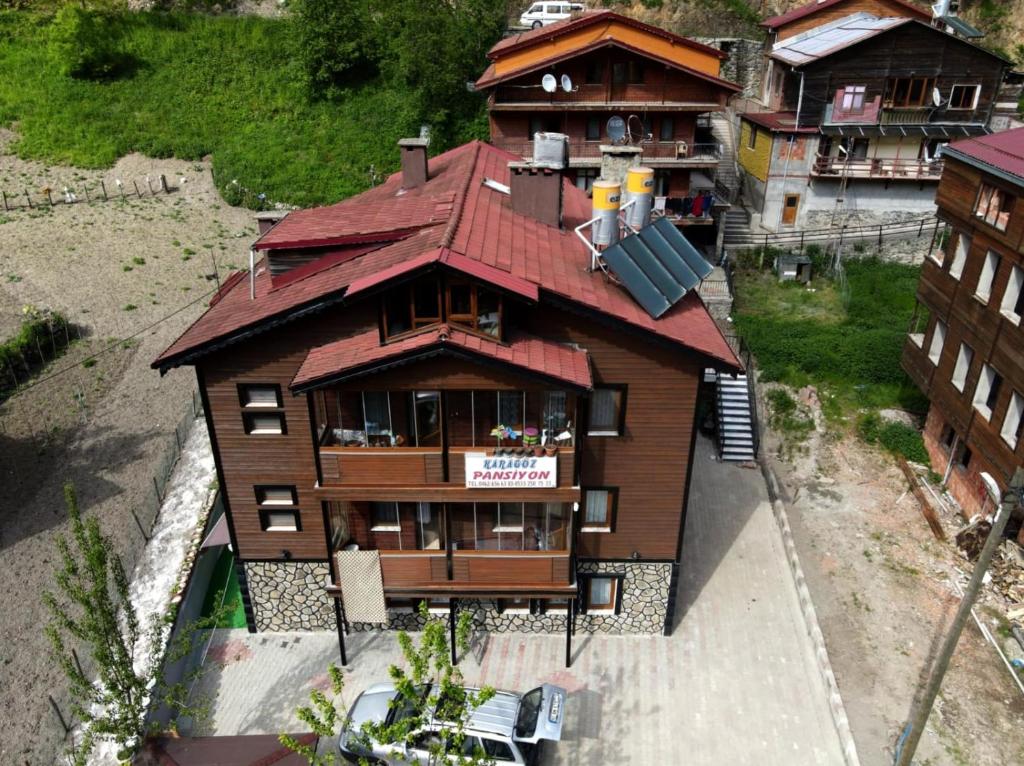 a large wooden house with a red roof at Karagoz Apart Pansiyon in Uzungol