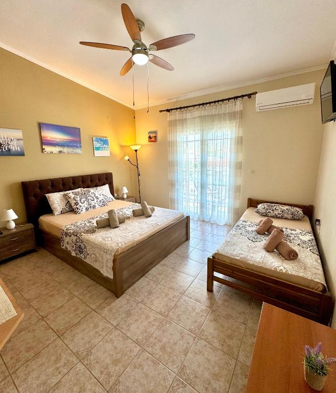 a bedroom with two beds and a ceiling fan at Theodora’s Studios in Repanídhion