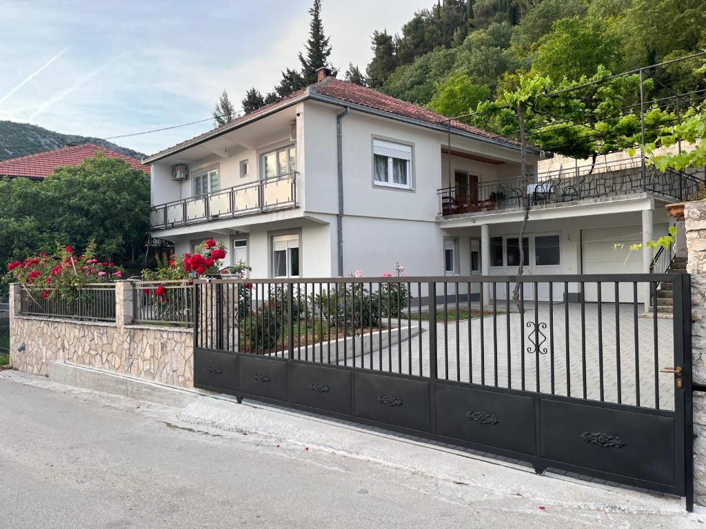 una casa blanca con una valla negra en Apartment Relax, en Stolac