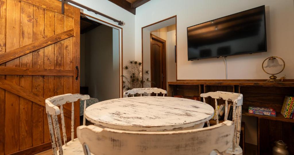 ein Zimmer mit einem Tisch und zwei Stühlen und einem Fernseher in der Unterkunft La casina de Peñaullan in Pravia