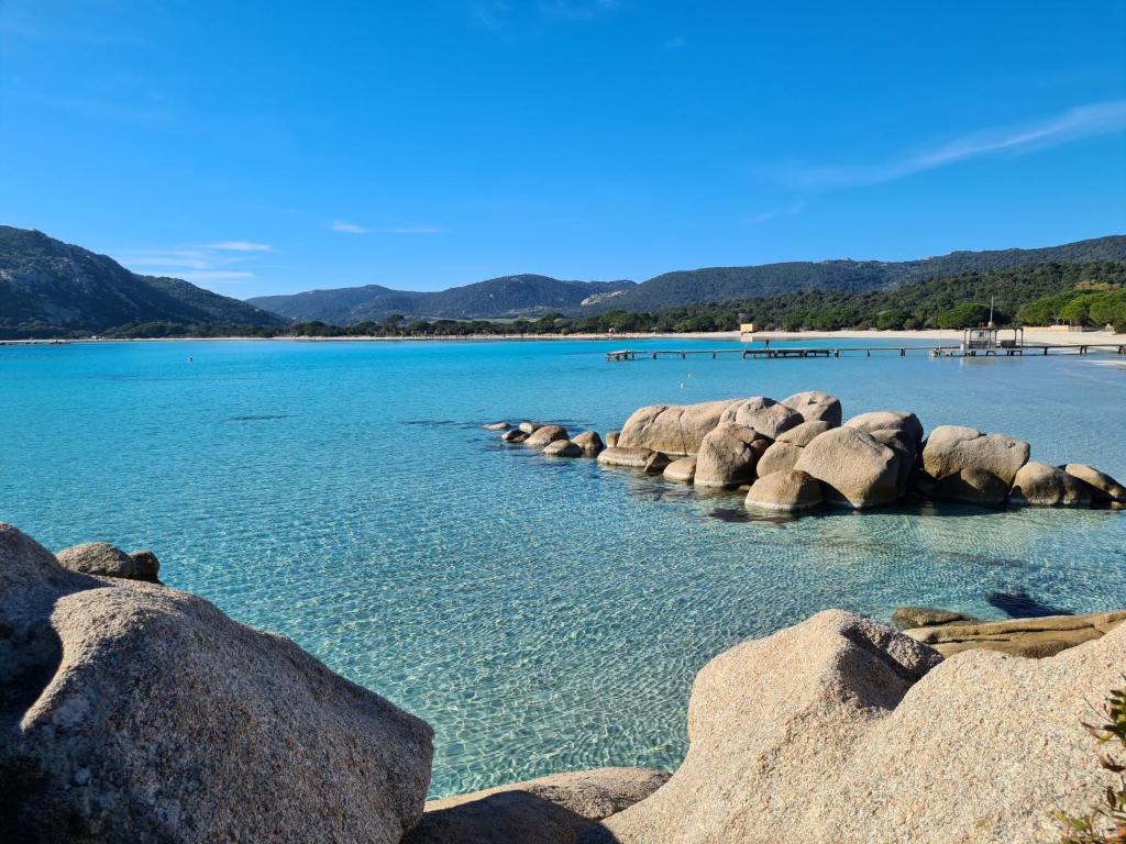 une grande étendue d'eau avec des rochers et une plage dans l'établissement Mini villa SANTA GIULIA, à Porto-Vecchio