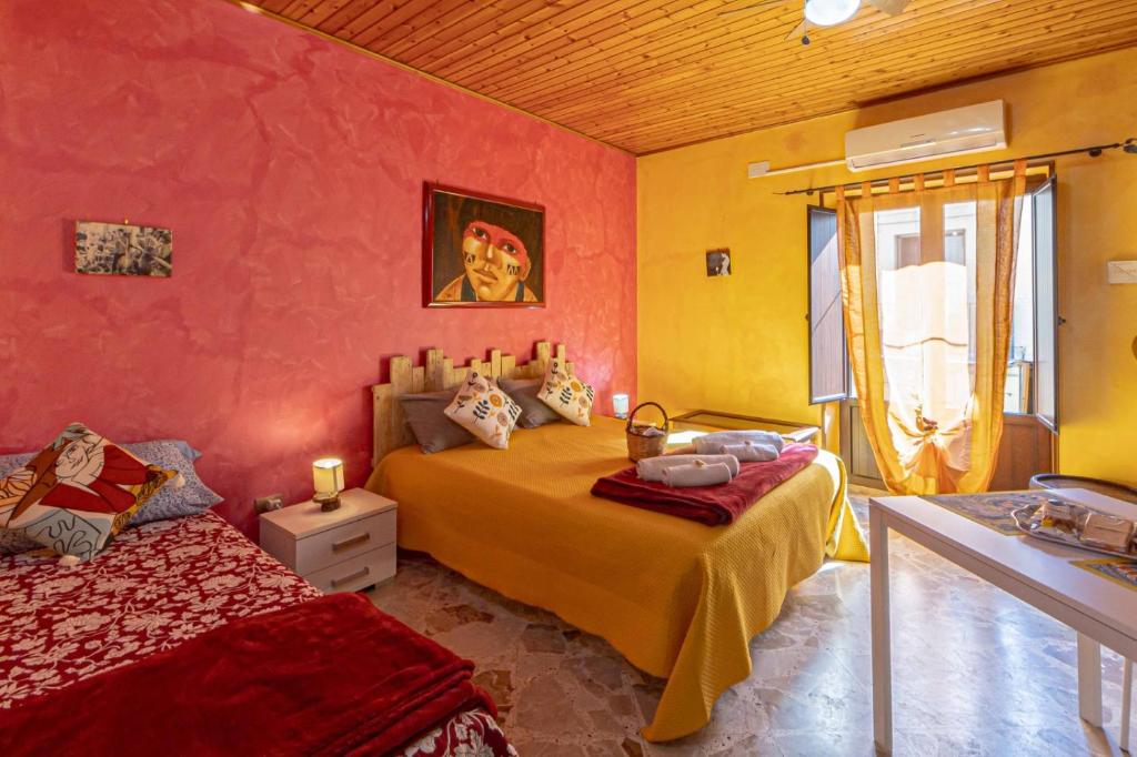 a bedroom with two beds and a window at Casa "a chiazzetta" in Castelbuono