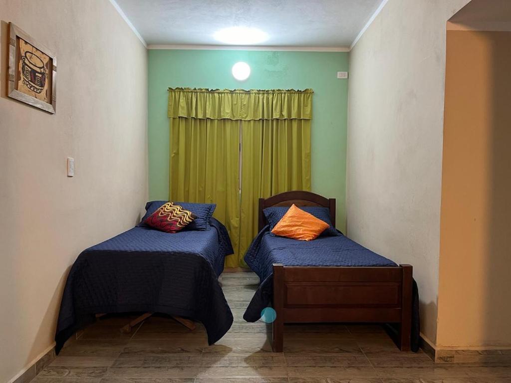 um quarto com duas camas e uma janela verde em Complejo Aloe Vera D em Villa Dolores