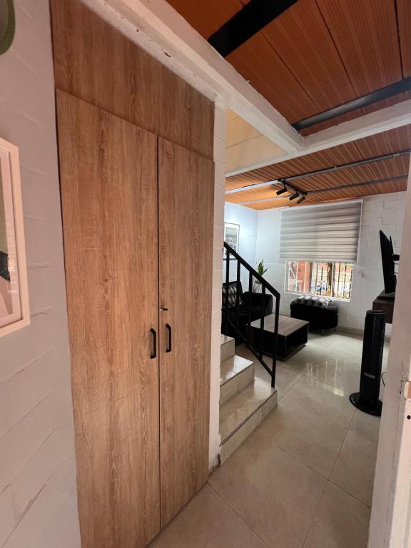 una gran puerta de madera en una habitación con una escalera en Casa amoblada lista para estrenar en Cali