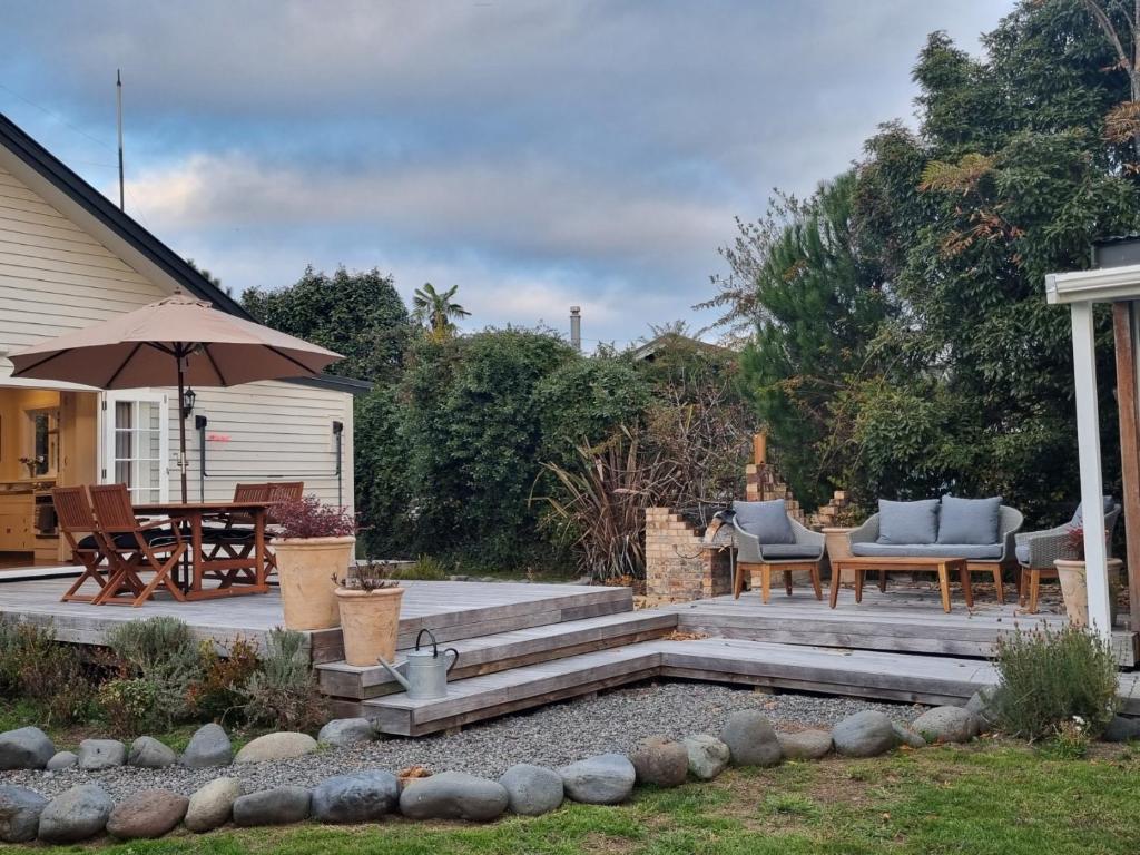 a patio with a table and chairs and an umbrella at Number 32 in Taumarunui