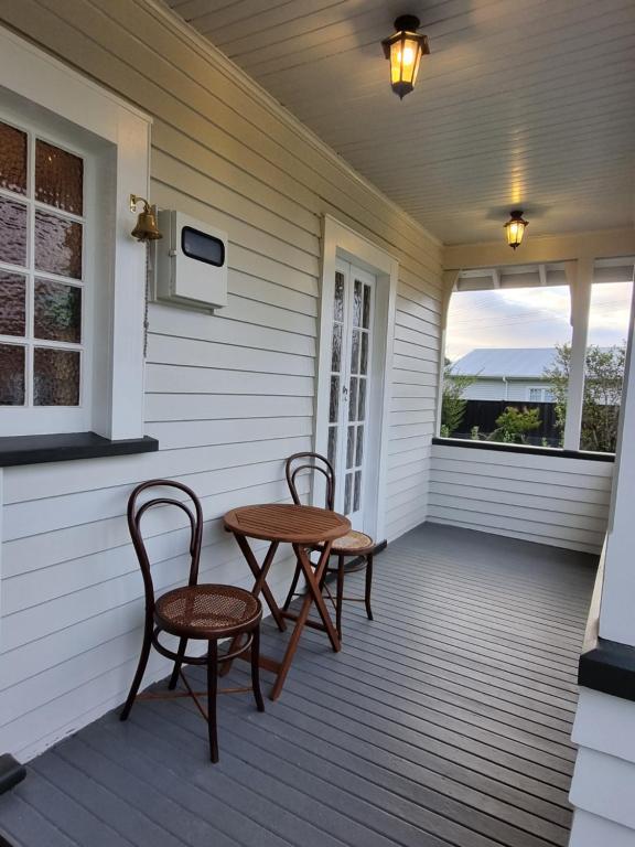 two chairs and a table on the porch of a house at Number 32 in Taumarunui