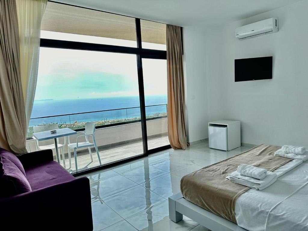 a bedroom with a bed and a view of the ocean at Wait 'n Sea in Himare