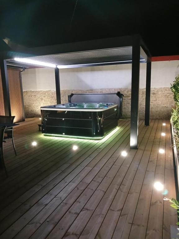a patio with a pool table on a deck at night at Gite avec Spa Le Rubis proche des plages du Débarquement Manche Normandie in Joganville