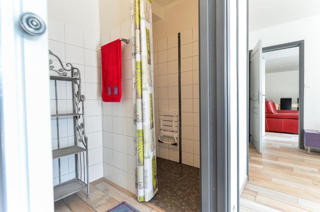 a bathroom with a shower and a red couch at Domaine de Kervail in Quimperlé