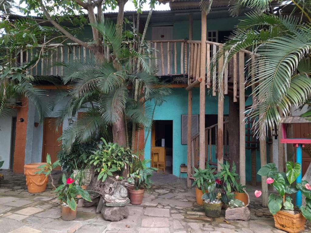 a house with palm trees and plants in front of it at Pousada Bora Bora in Guarapari