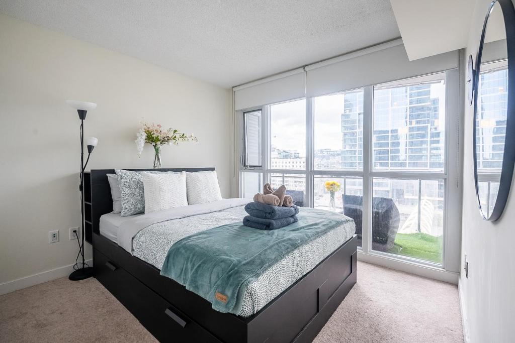 a bedroom with a bed and a large window at Stunning Luxurious LakeView Condo by CN Tower in Toronto