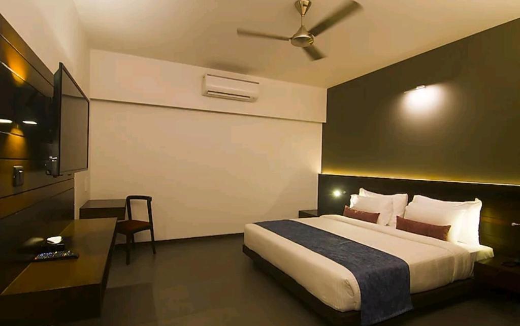a hotel room with a bed and a television at Janardana Resorts in Vrindāvan