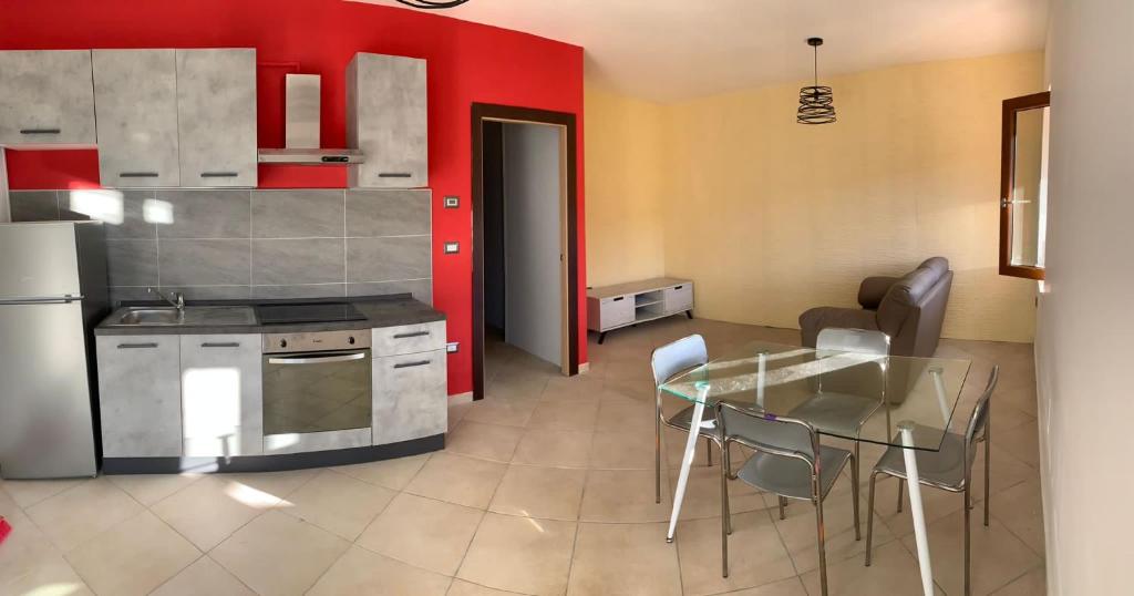 una cucina con tavolo e una cucina con pareti rosse di Casa del Lago a Pignola