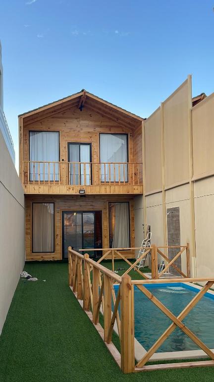 ein Haus mit einer Terrasse und einem Pool in der Unterkunft درة العروس اكواخ الدره in Durrat Al-Arus