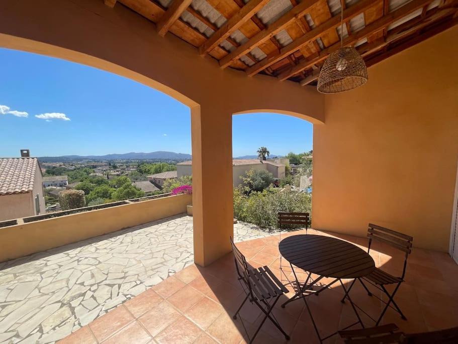 un patio avec une table et des chaises sur un balcon dans l'établissement Maisonnette calme vue collines, à Marseille