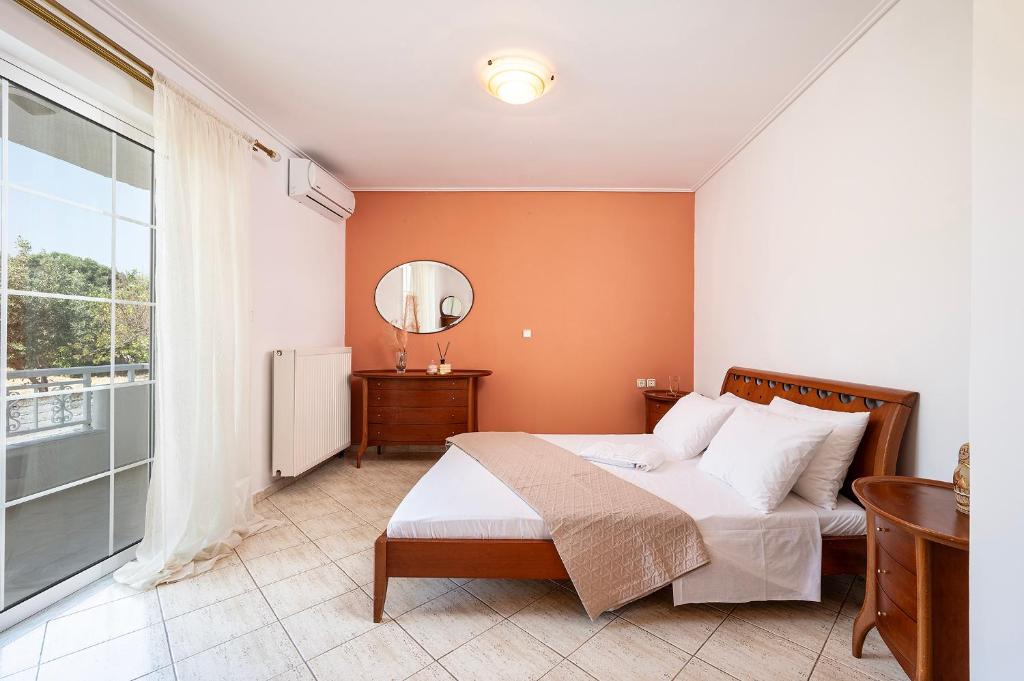a bedroom with a bed and a large window at Aegean Whispers House in Psalidi