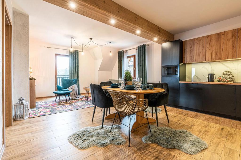 eine Küche und ein Esszimmer mit einem Tisch und Stühlen in der Unterkunft Apartamenty widokowe "u Homera" in Zakopane