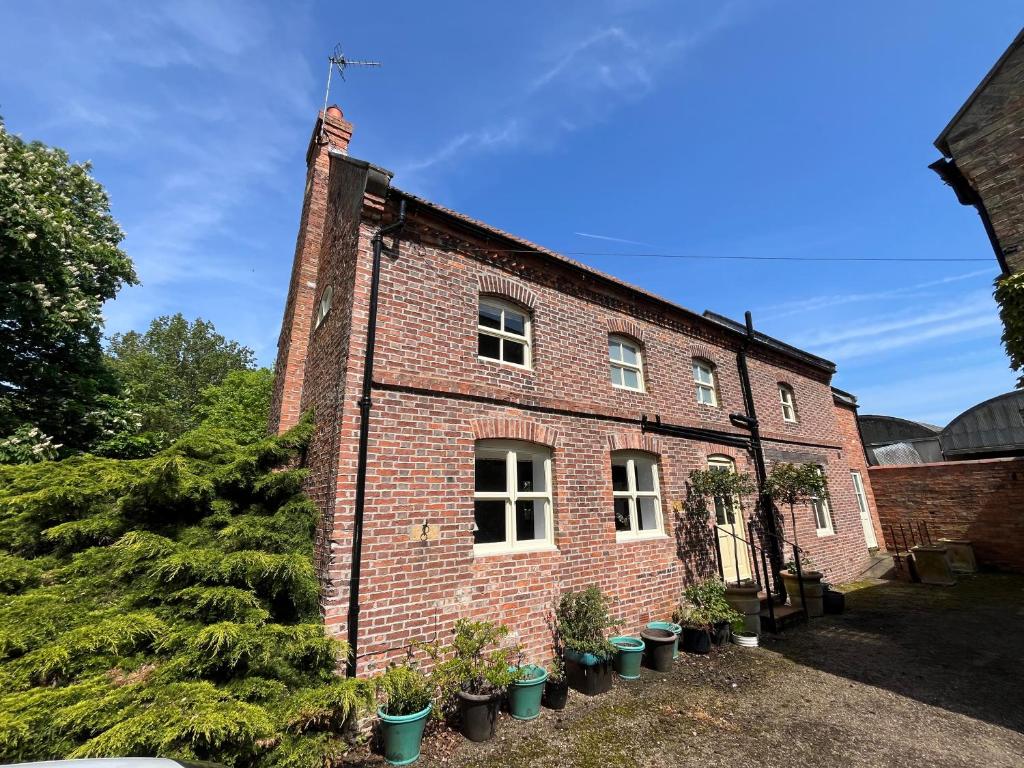 Un vecchio edificio di mattoni con una bandiera americana sopra. di The Old Barn a Market Rasen