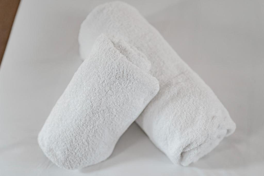 a pair of white towels sitting on a table at Stylish home w/ parkng, fst wifi in Cambourne