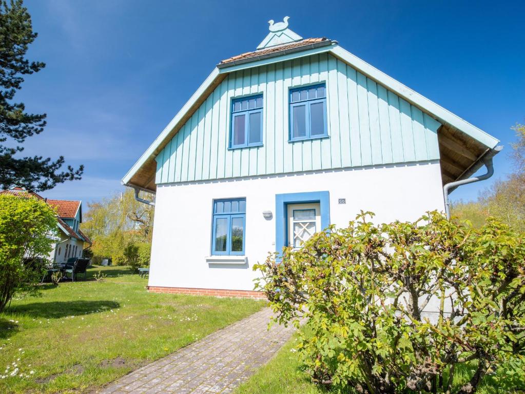 a white house with a gambrel roof at Ferienhaussiedlung Strandperlen Weidenhof 6b (Typ IX) in Wustrow