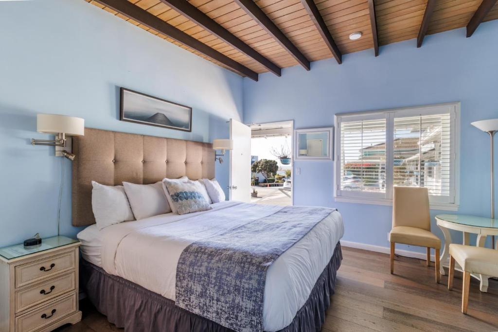 a bedroom with a large bed and a table at Pleasant Inn in Morro Bay