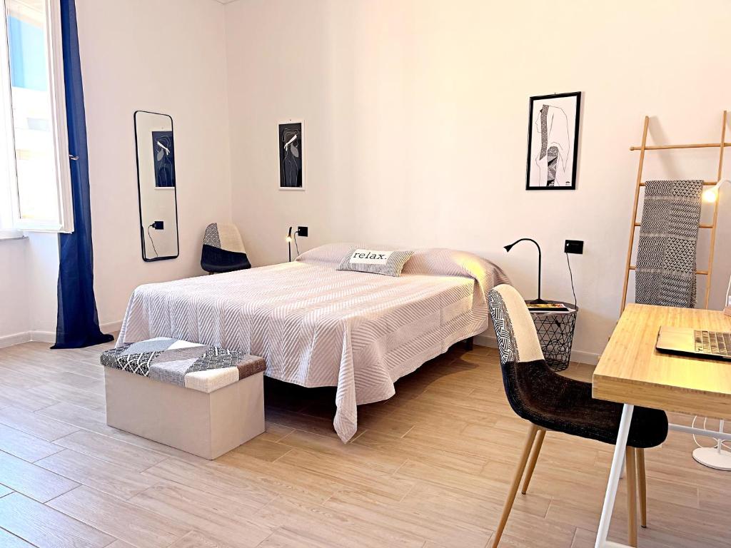 a bedroom with a bed and a table and a desk at DomoMea - L'Isola nell'Isola - R3442 in La Maddalena