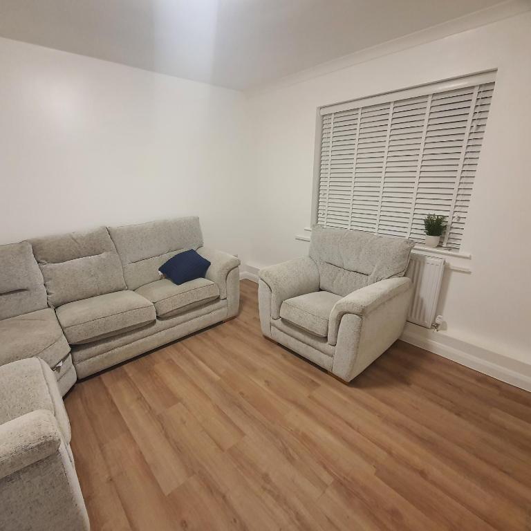 a living room with a couch and a chair at Beautiful place near Dagenham East Station in Dagenham