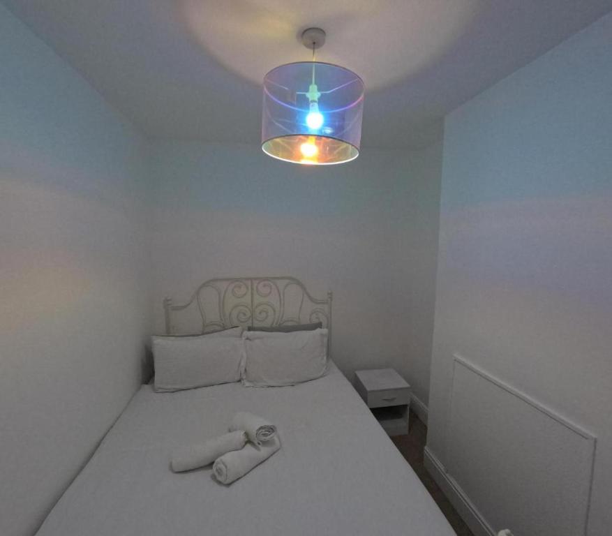 ein Schlafzimmer mit einem weißen Bett mit blauem Licht in der Unterkunft Double bedroom in Portsmouth