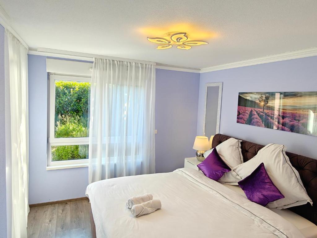 Un dormitorio con una cama grande y una ventana en Charming apartment with Garden, Free Parking near Basel, Airport, Ger'many, France,, en Saint-Louis