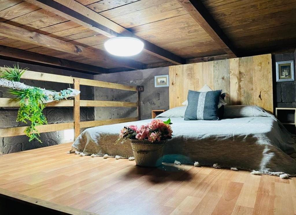 1 dormitorio con 1 cama y suelo de madera en Moderna cabaña con Jacuzzi, en Huasca de Ocampo