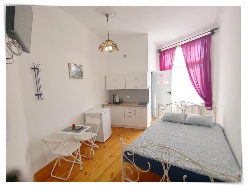 1 dormitorio con cama, mesa y cocina en SouvenirAppart Sniadeckich 45 en Bydgoszcz