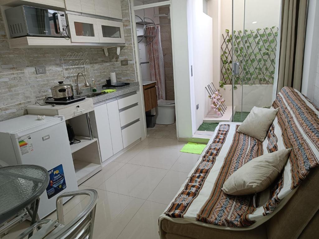Studio Arenas في أريكيبا: غرفة معيشة مع أريكة ومطبخ