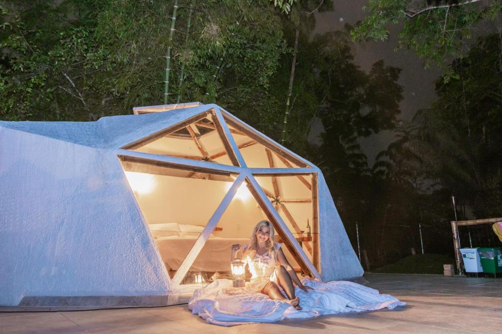 a woman is sitting in a blue tent at Glamping Domo Ibagué in Ibagué