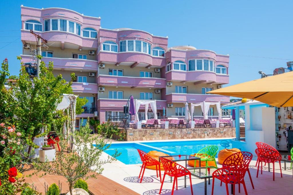 un hotel con piscina, mesas y sillas en Accommodation Royal Azur, en Dobra Voda